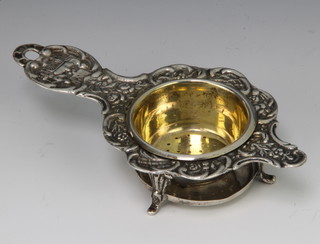 A Continental silver tea strainer with fancy handle and stand 12cm 