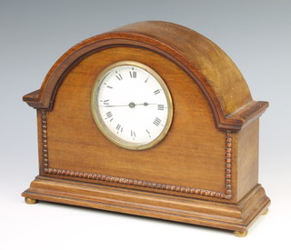 A 1930's French bedroom timepiece with enamelled dial and Roman numerals contained in an arched walnut case 