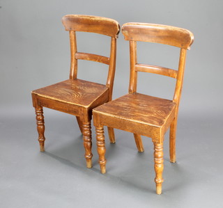A pair of George III Country elm bar back hall chairs with solid seats raised on turned supports 