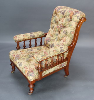 A Victorian mahogany show frame armchair with bobbin turned decoration upholstered in floral buttoned material 