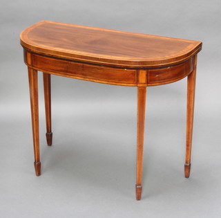 A Georgian mahogany crossbanded demi-lune card table inlaid satinwood stringing, raised on square tapered supports 74cm h x 91cm w x 45cm d 