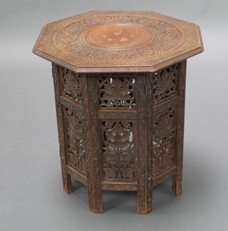 An Indian carved hardwood and inlaid brass octagonal folding occasional table raised on a pierced folding stand 47cm h x 46cm x 45cm 