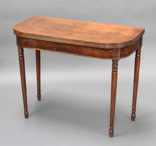 A Georgian mahogany D shaped folding tea table raised on turned supports 73cm h x 91cm w x 45cm d 