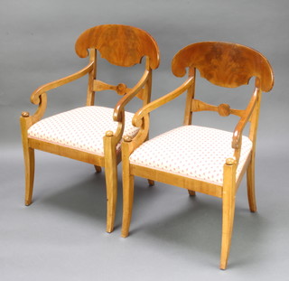 A pair of 19th Century Biedermeier bar back carver chairs with upholstered seats, raised on sabre supports 