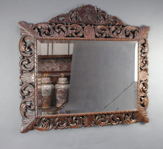 A Victorian rectangular bevelled plate wall mirror contained in a carved and pierced oak frame 109cm x 82cm (some small holes to the frame) together with an associated carved and pierced oak lion crest