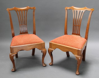 A pair of Georgian Chippendale style slat back dining chairs with pierced vase shaped slat backs and upholstered drop in seats, raised on cabriole supports