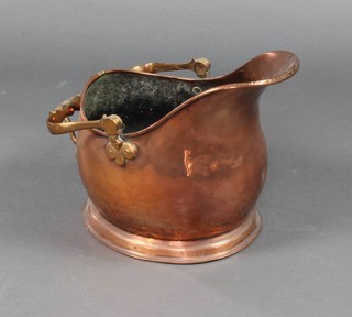 A copper helmet shaped coal scuttle with brass swing handle (some dents) 