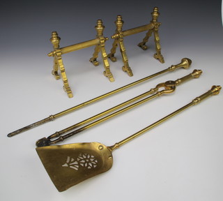 A pair of Art Nouveau reeded brass fire dogs together with a matching pair of tongs, shovel and an associated poker 