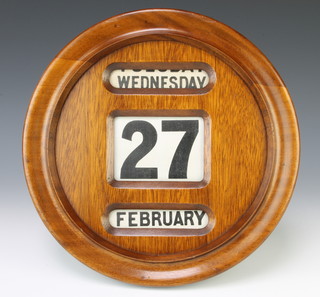 An Edwardian perpetual calendar contained in a circular oak case 32cm diam. 