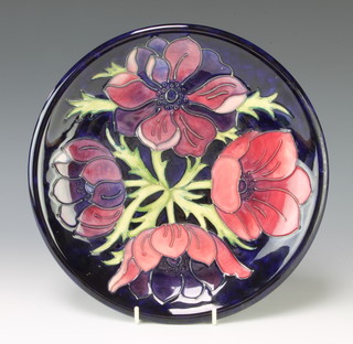 A modern Moorcroft blue ground plate decorated with anemones 26cm 