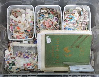 A plastic crate containing loose world stamps