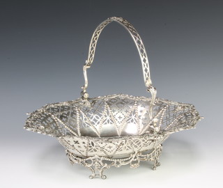 A Georgian cast and pierced silver swing handled basket with floral and scroll decoration on rustic base 1374 grams, 38cm 