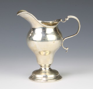 An Edwardian silver cream jug with S scroll handle Birmingham 1909 107 grams