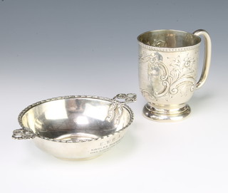 A Victorian repousse silver mug Chester 1899 with presentation inscription 72 grams 7cm and an Edwardian silver taste vin with ribbon handles London 1907 60grams 