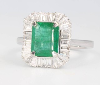 An 18ct white gold Art Deco style emerald and diamond ring, the centre stone approx. 1.7ct surrounded by tapered baguette and baguette diamonds 0.61ct, size M 1/2 