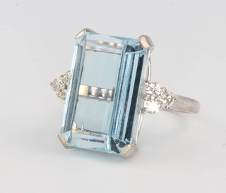 An 18ct white gold emerald cut aquamarine and diamond ring, the centre stone 13ct flanked by 3 brilliant cut diamonds to each shoulder, size O 1/2