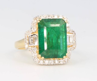 An 18ct yellow gold emerald and diamond cluster ring, the centre stone 4.58ct surrounded by diamonds 0.58ct, size O 