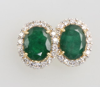 A pair of yellow gold oval emerald and diamond ear studs, the emeralds approx. 6.0ct surrounded by brilliant cut diamonds approx. 2ct 