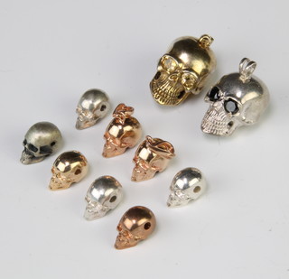 Ten silver skull charms, 61 grams 