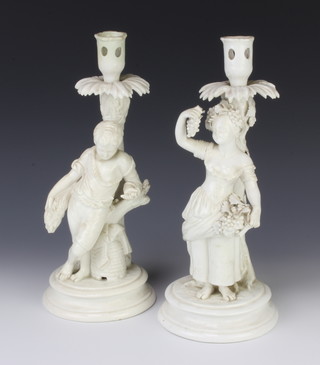 A pair of 19th Century Stephenson and Hancock white glazed candlesticks with figural bases, a lady carrying grapes and a boy beside a beehive 34cm 