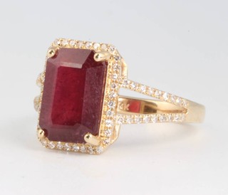 A 14ct yellow gold ruby and diamond ring, the  rectangular treated centre stone 4.1ct surrounded by brilliant cut diamonds approx. 0.5ct, size M 1/2