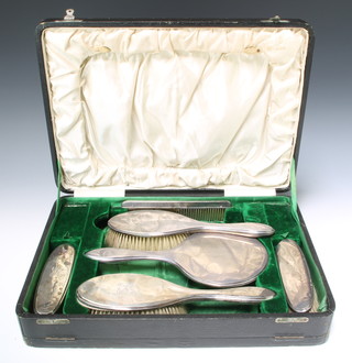 A cased silver dressing table set comprising hand mirror 2 clothes brushes 2 hair brushes and a comb Birmingham 1915/16