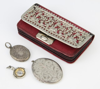 A silver charm in the form of a swivel compass, 2 silver lockets and a mounted purse 