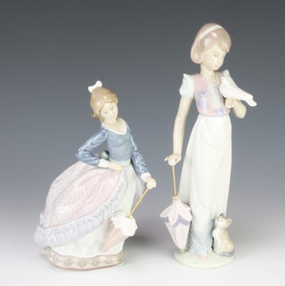 A Lladro figure of a young lady with parasol 18cm, do. with a dove and kitten 7611 23cm  
