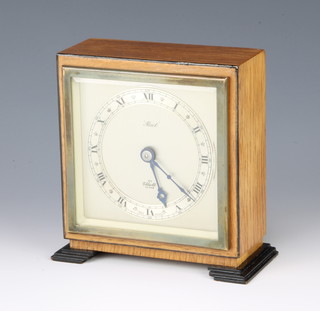 Elliott, a 1950's mantel timepiece the square silvered dial marked Reid contained in an oak case, raised on ebonised bracket feet 