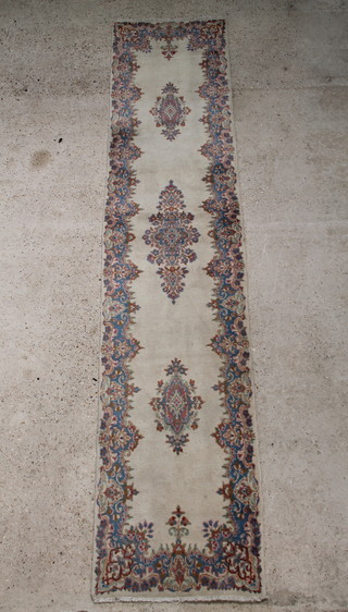 A white and floral ground Persian Kurman runner with 3 medallions to the centre 350cm x 75cm 