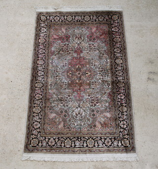 A pink ground Persian silk rug with central medallion within multi row borders 191cm x 122cm 