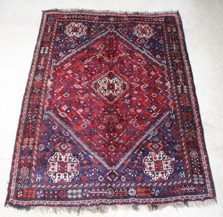 A blue and red ground Persian Qashqai carpet with diamond to the centre 291cm x 219cm, in wear 
