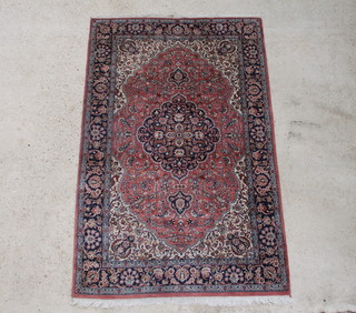 A pink and blue ground Persian rug with central medallion within a multi row border 189cm x 122cm