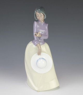 A Nao figure of a lady holding a hat and bird 27cm 
