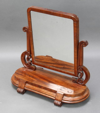 A Victorian arch plate dressing table mirror contained in a mahogany swing frame raised on an oval mahogany base with scroll feet 70cm x 72cm x 34cm d (some pitting to the silvering and ring marks to the base) 