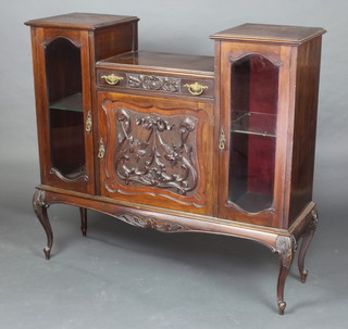 An Edwardian carved mahogany cabinet, the centre section fitted a drawer above a cupboard flanked by a pair of cupboards enclosed by glazed panelled doors, raised on cabriole supports 112cm h x 122cm w x 36cm d 