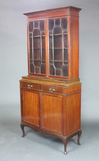 An Edwardian Georgian style mahogany display cabinet on cabinet, the upper section with moulded cornice, the interior fitted adjustable shelves enclosed by astragal glazed panelled doors, base fitted 2 long drawers above a double cupboard enclosed by a panelled door, raised on cabriole supports 200cm h x 93cm w x 38cm d 