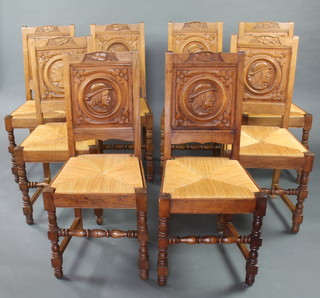 A set of 8 French carved oak dining chairs, the carved backs depicting portraits of ladies and gentlemen with woven rush seats, raised on turned and block supports  