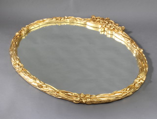 An oval shaped plate mirror contained in a decorative gilt frame with garland decoration 105cm x 114cm d 
