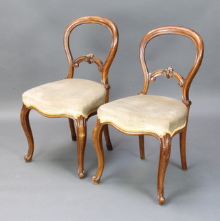 A pair of Victorian walnut balloon back dining chairs with over stuffed seats (some old but treated worm) 