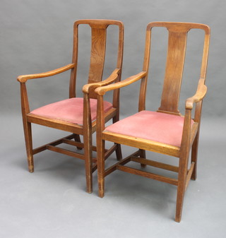 A pair of 1930's Art Deco oak slat back carver chairs with upholstered drop in seats, raised on square supports 