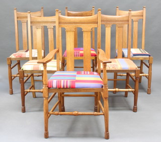A set of 6 Art Nouveau light oak slat back dining chairs raised on turned supports, comprising a carver and 5 standard chairs 