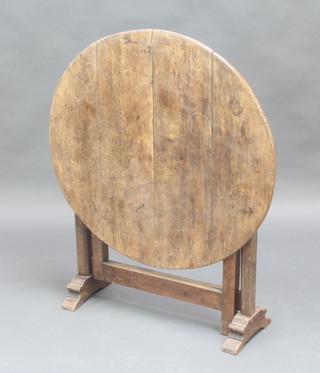A circular carved oak folding coaching table 70cm x 74cm 
