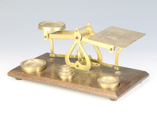 A pair of brass letter scales on an oak base complete with weights