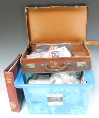 A leather attache case containing a small collection of loose world stamps and a green crate of loose stamps, first day covers, postcards etc