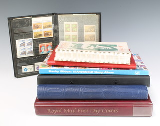 An album of Elizabeth II GB first day covers, an Atlas stamp album of mint and used GB and world stamps, a loose leaf album of Elizabeth II used stamps, a Transworld album of used world stamps, a stock book of world stamps and a 1995 US/BNA postage stamp catalogue 