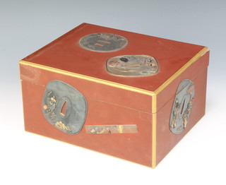 A Meiji period Japanese red lacquer box decorated with lacqured Tsuba and sword mounts, 11cm x 25cm x 20cm 
