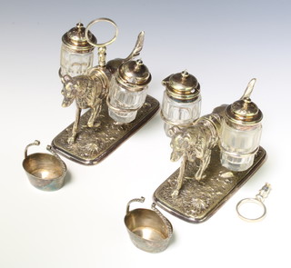 A pair of Edwardian silver plated condiments in the form of hounds carrying mounted bottles with baskets in their mouths 