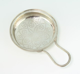 A Georgian silver lemon strainer with geometric pierced decoration and beaded handle with clip, London 1783, by William Abdy I 