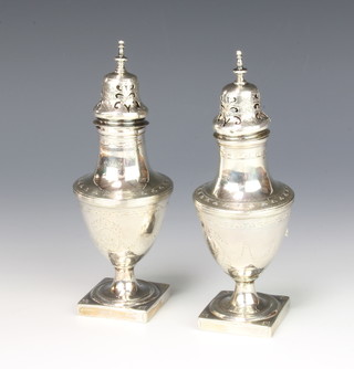 A pair of Georgian silver casters of urn shape on square bases 16cm 192 grams 
